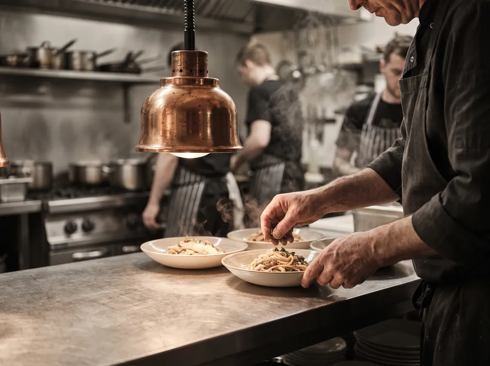 Il pass di un ristorante durante il servizio, con i piatti pronti sotto la lampada.
